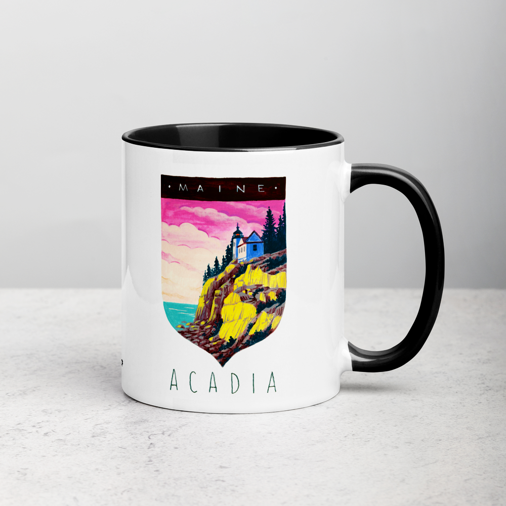 White ceramic coffee mug with black handle and inside; has Acadia National Park illustration by Angela Staehling