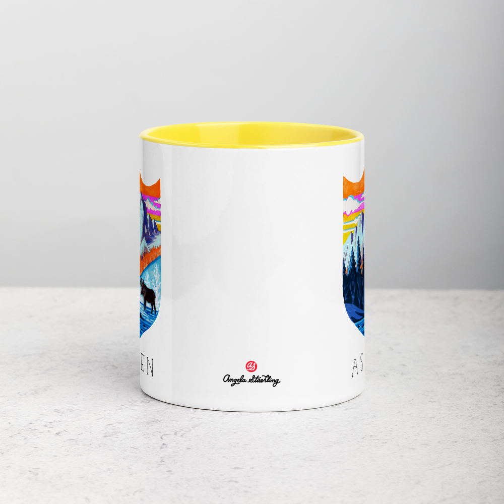 White ceramic coffee mug with yellow handle and inside; has Aspen Colorado illustration by Angela Staehling