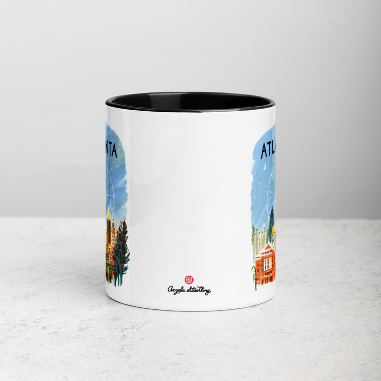 White ceramic coffee mug with black handle and inside; has Atlanta illustration by Angela Staehling