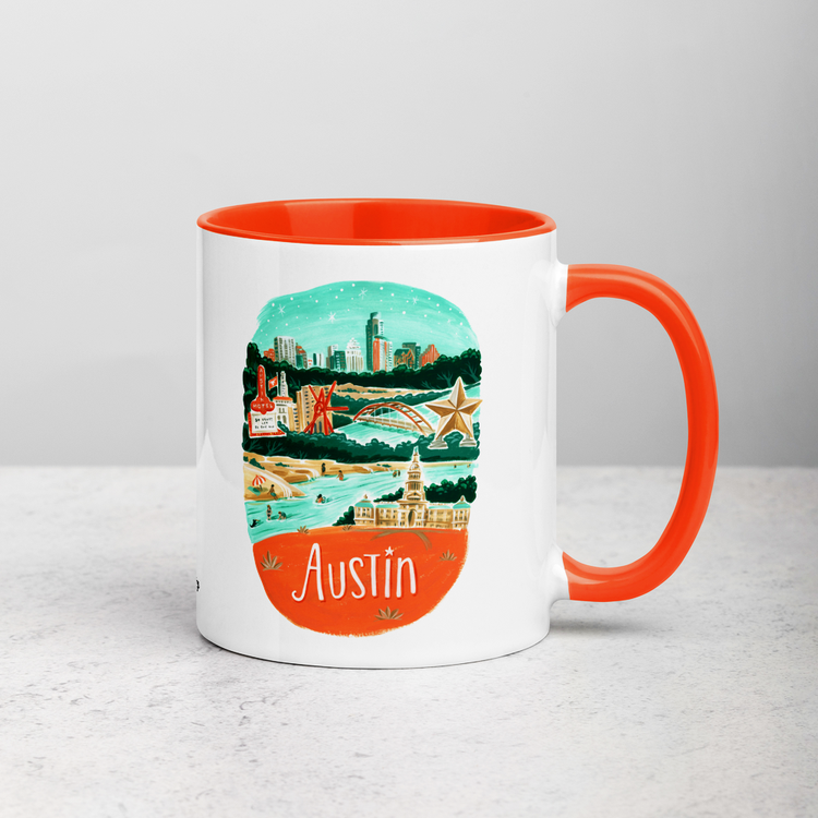 White ceramic coffee mug with orange handle and inside; has Austin illustration by Angela Staehling