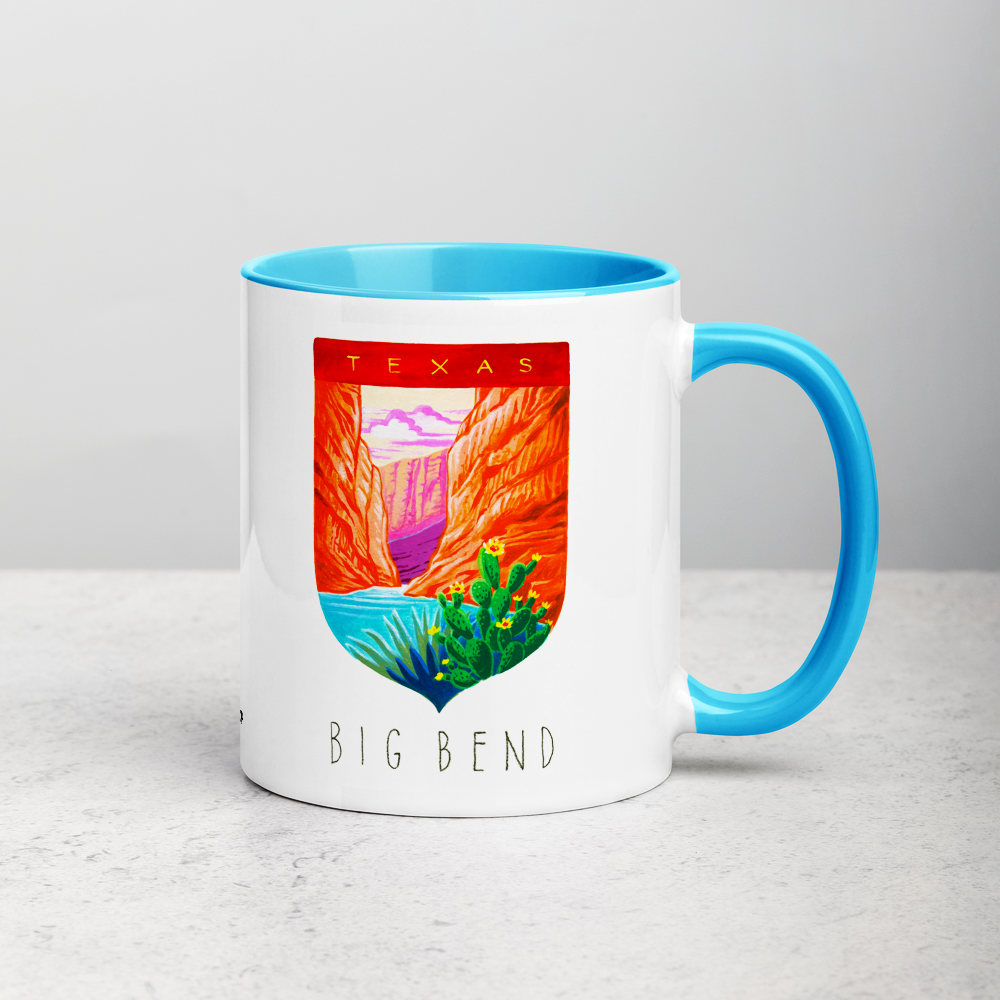 White ceramic coffee mug with blue handle and inside; has Big Bend National Park illustration by Angela Staehling