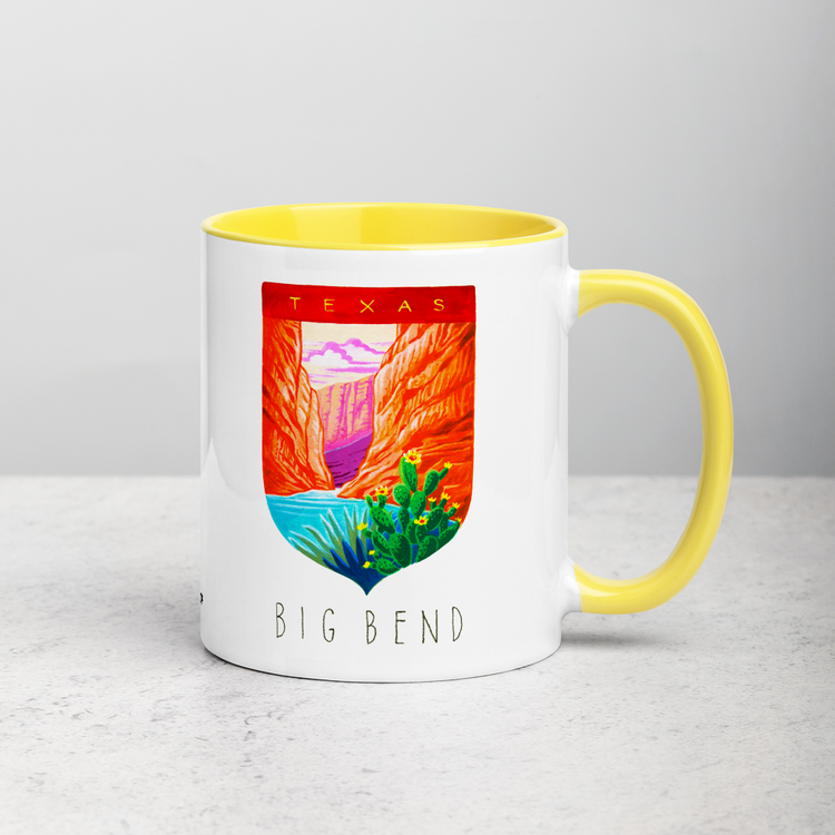 White ceramic coffee mug with yellow handle and inside; has Big Bend National Park illustration by Angela Staehling