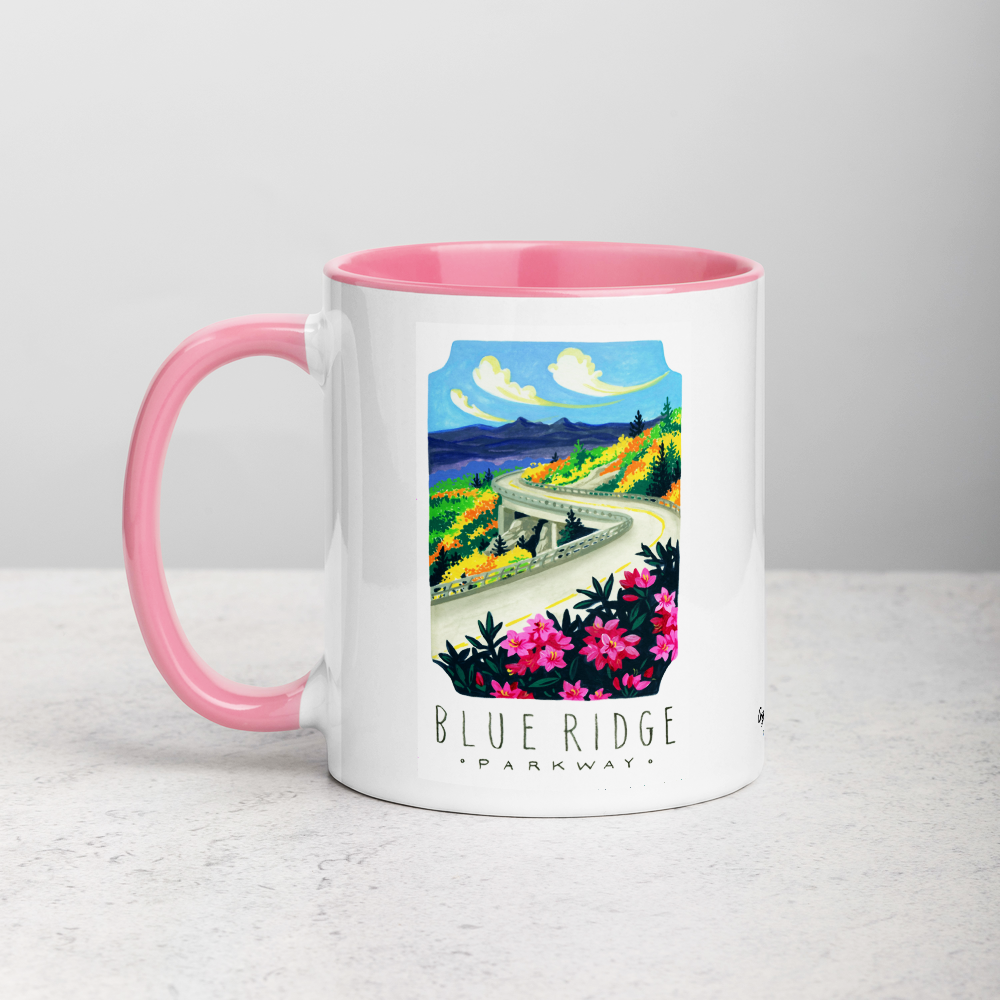 White ceramic coffee mug with pink handle and inside; has Blue Ridge Parkway National Park illustration by Angela Staehling