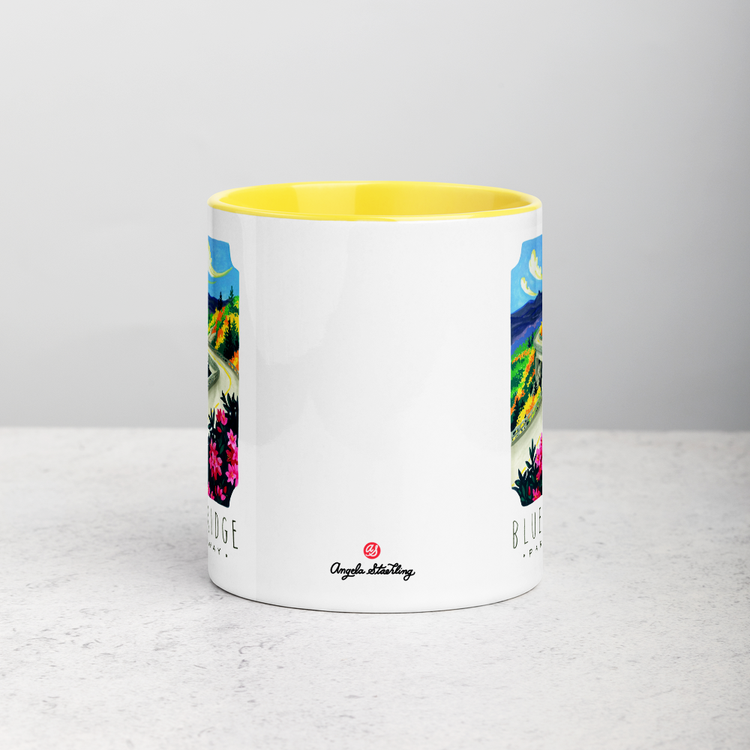 White ceramic coffee mug with yellow handle and inside; has Blue Ridge Parkway National Park illustration by Angela Staehling
