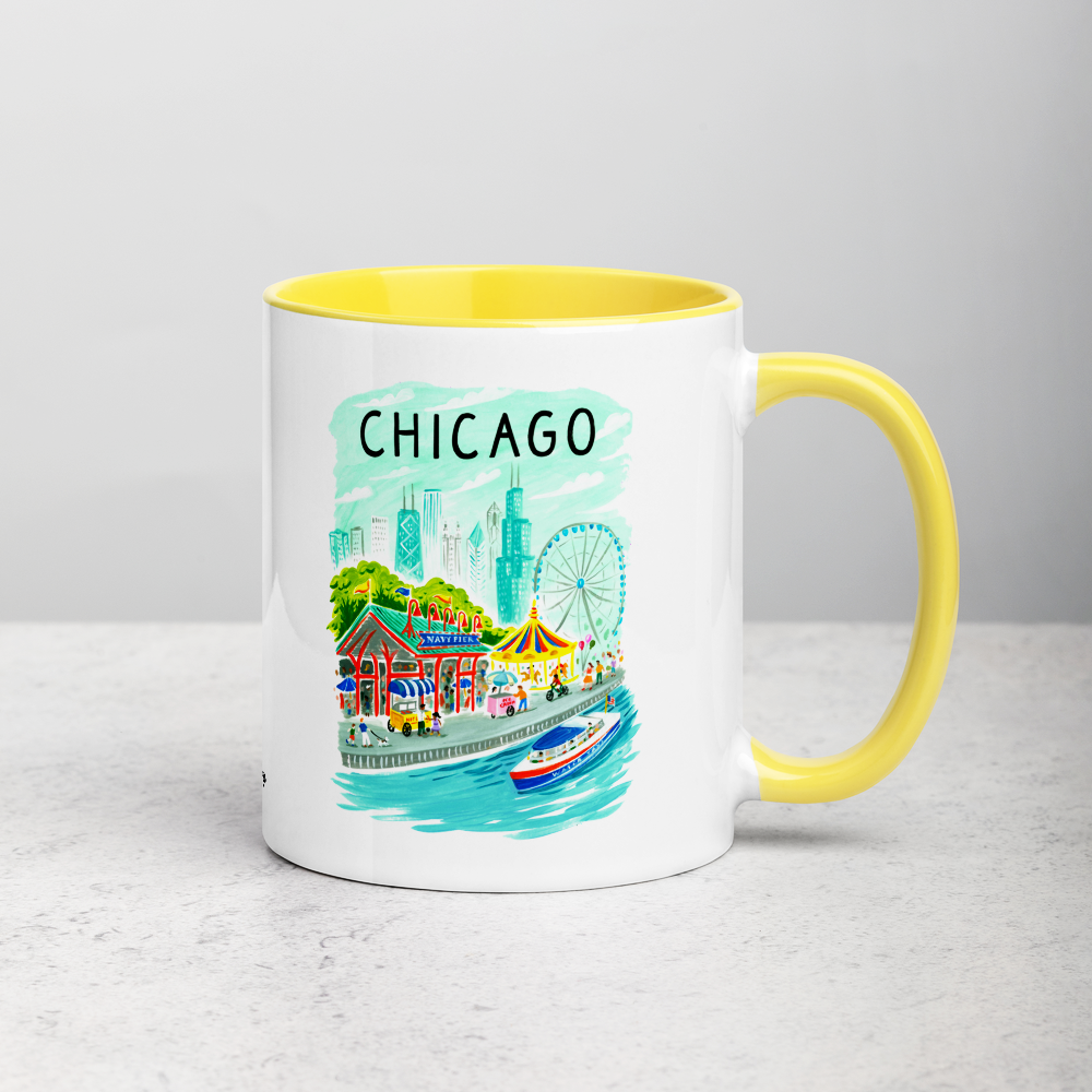 White ceramic coffee mug with yellow handle and inside; has Chicago Navy Pier illustration by Angela Staehling