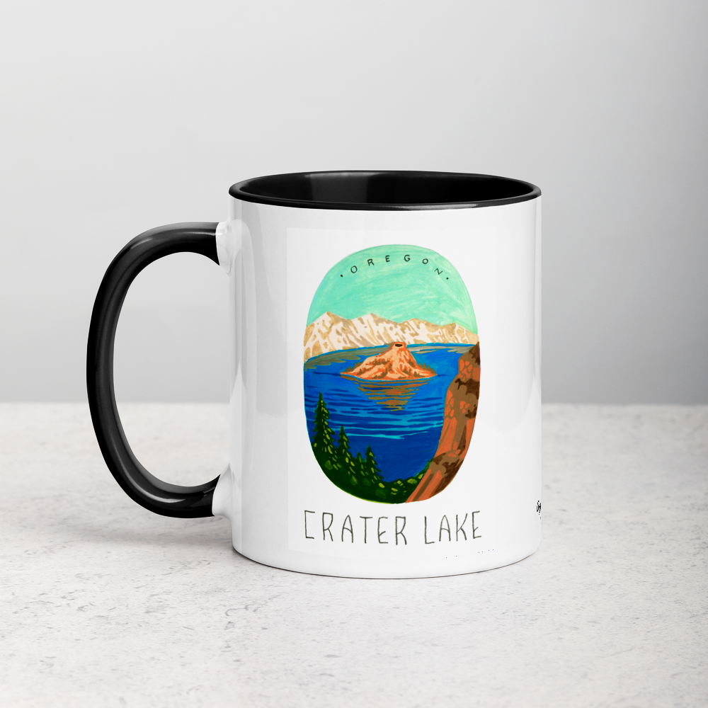 White ceramic coffee mug with black handle and inside; has Crater Lake National Park illustration by Angela Staehling