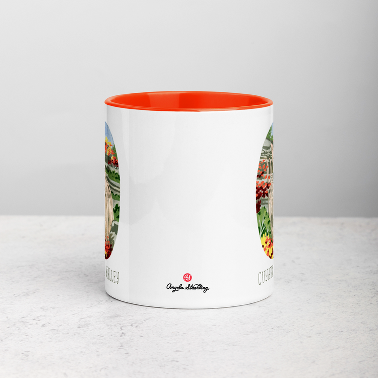 White ceramic coffee mug with orange handle and inside; has Cuyahoga Valley National Park illustration by Angela Staehling