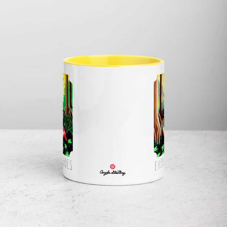 White ceramic coffee mug with yellow handle and inside; has Everglades National Park illustration by Angela Staehling