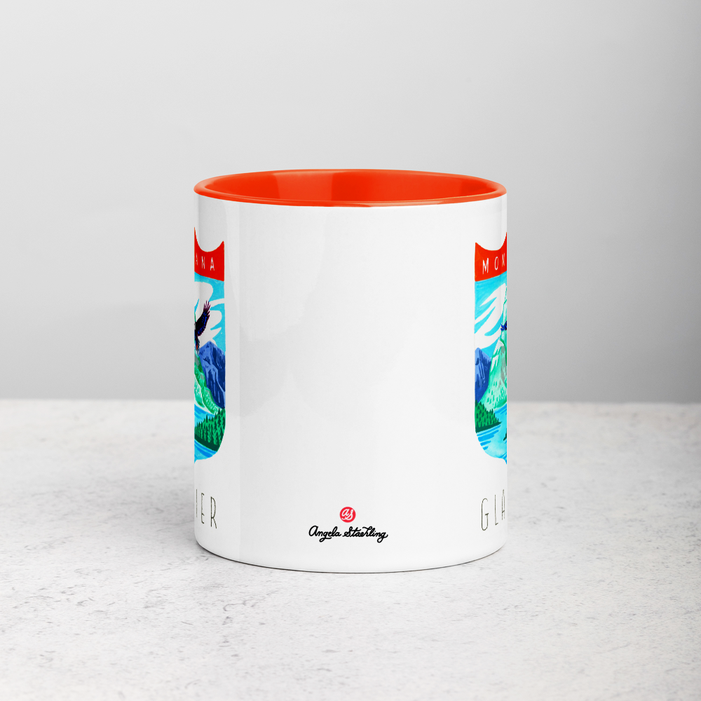 White ceramic coffee mug with orange handle and inside; has Glacier National Park illustration by Angela Staehling