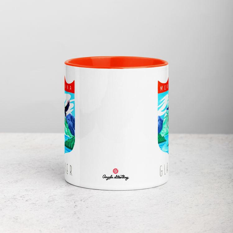 White ceramic coffee mug with orange handle and inside; has Glacier National Park illustration by Angela Staehling