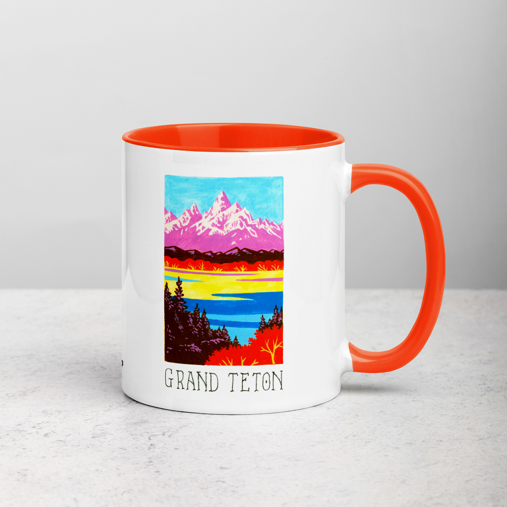 White ceramic coffee mug with orange handle and inside; has Grand Teton National Park illustration by Angela Staehling