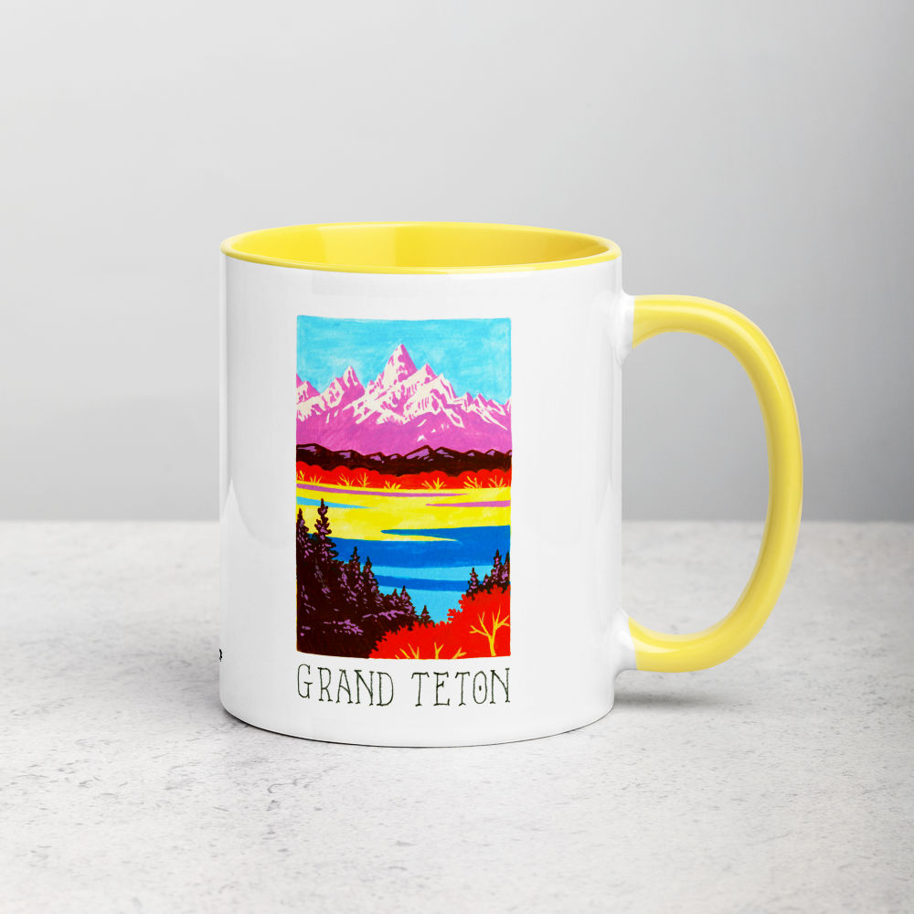 White ceramic coffee mug with yellow handle and inside; has Grand Teton National Park illustration by Angela Staehling