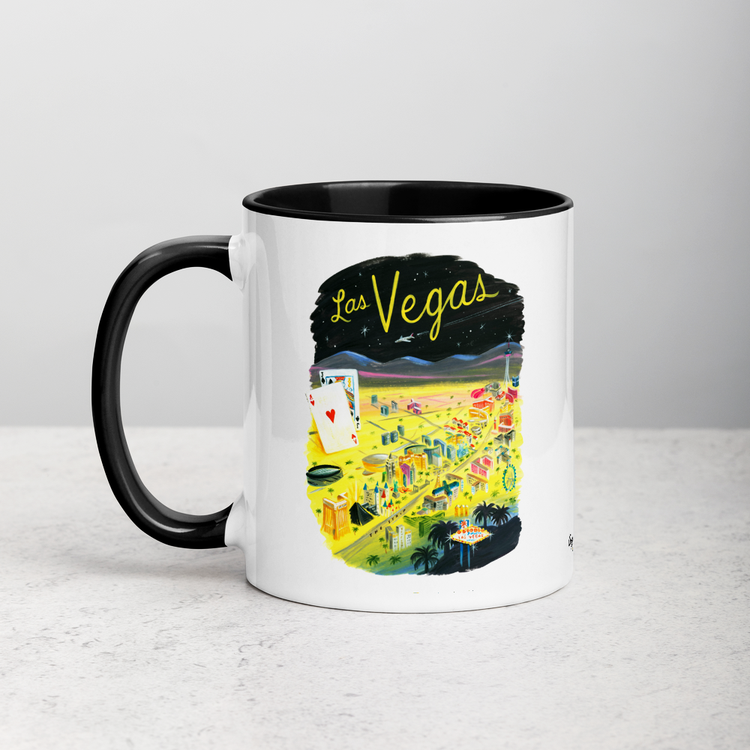 White ceramic coffee mug with black handle and inside; has Las Vegas illustration by Angela Staehling