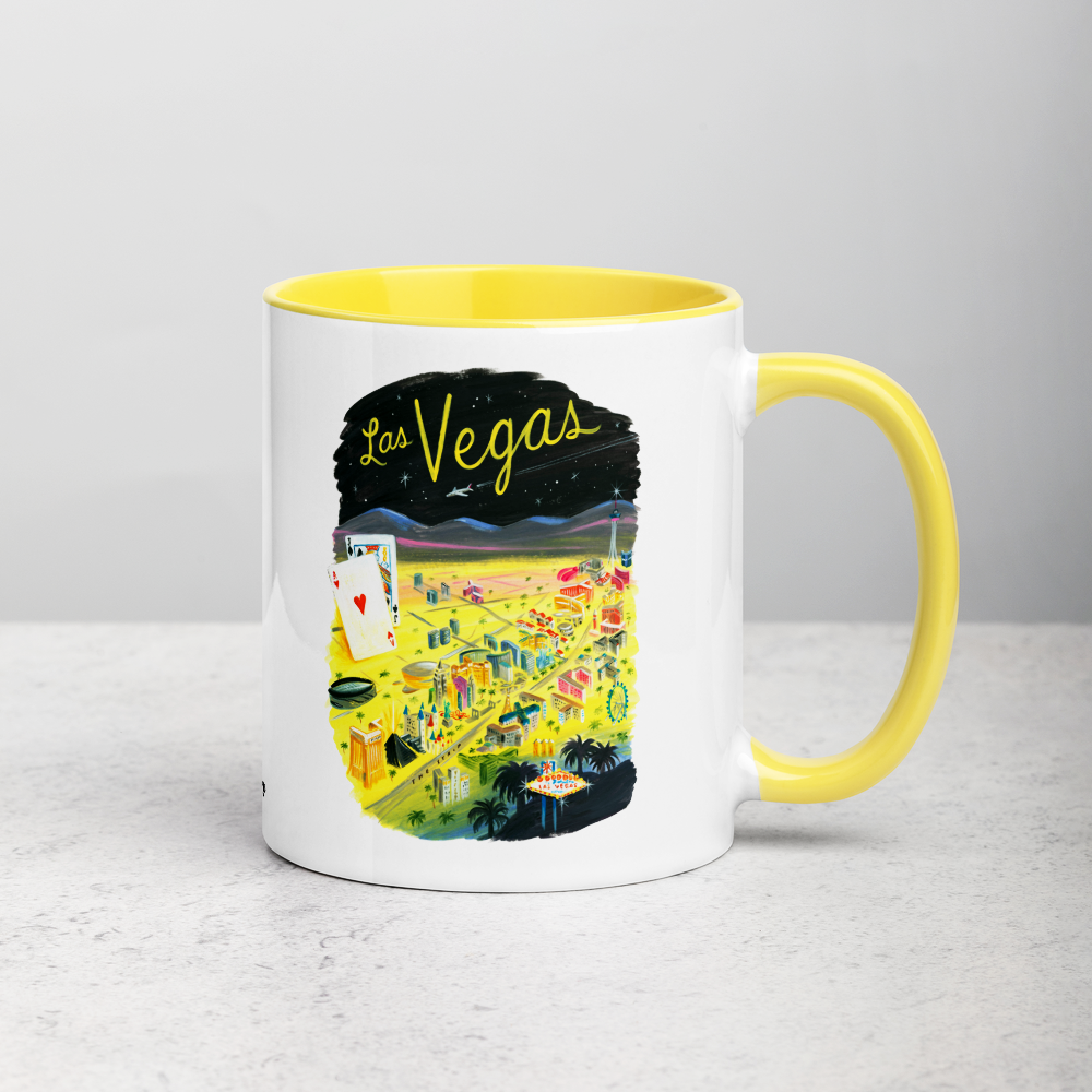 White ceramic coffee mug with yellow handle and inside; has Las Vegas illustration by Angela Staehling