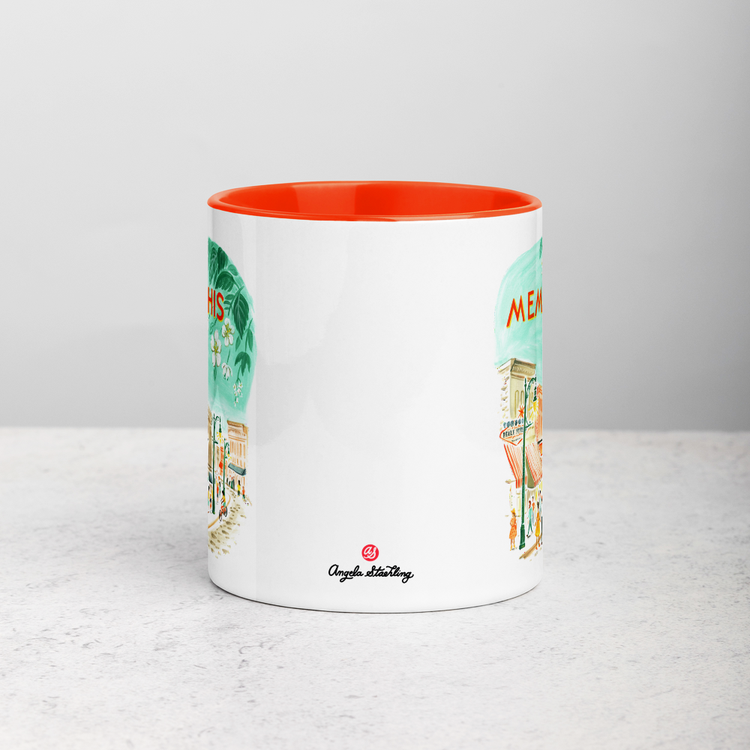 White ceramic coffee mug with orange handle and inside; has Memphis Tennessee illustration by Angela Staehling