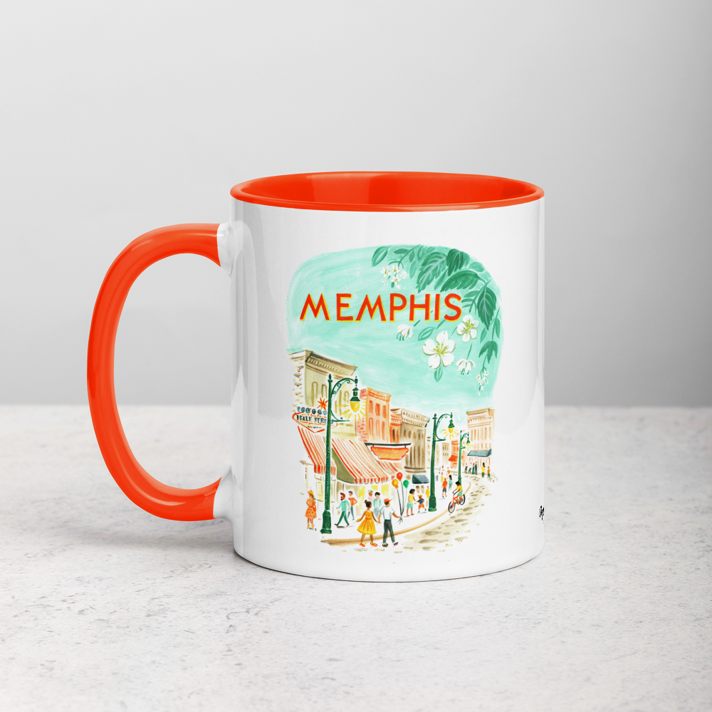 White ceramic coffee mug with orange handle and inside; has Memphis Tennessee illustration by Angela Staehling
