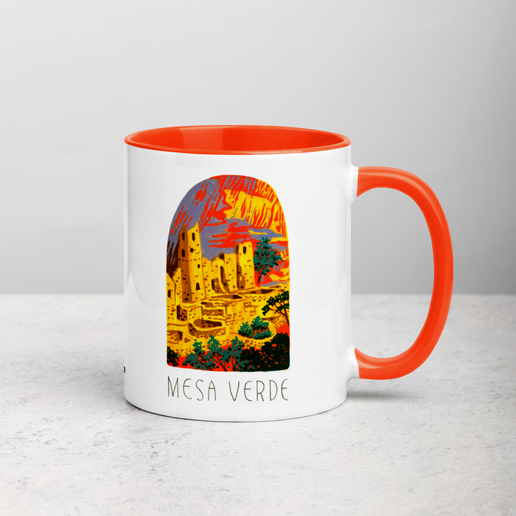 White ceramic coffee mug with orange handle and inside; has Mesa Verde National Park illustration by Angela Staehling