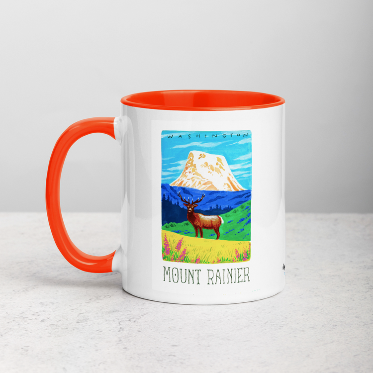 White ceramic coffee mug with orange handle and inside; has Mount Rainier National Park illustration by Angela Staehling