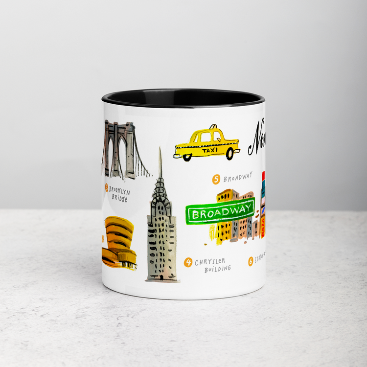 White ceramic coffee mug with black handle and inside; has New York landmarks illustration by Angela Staehling