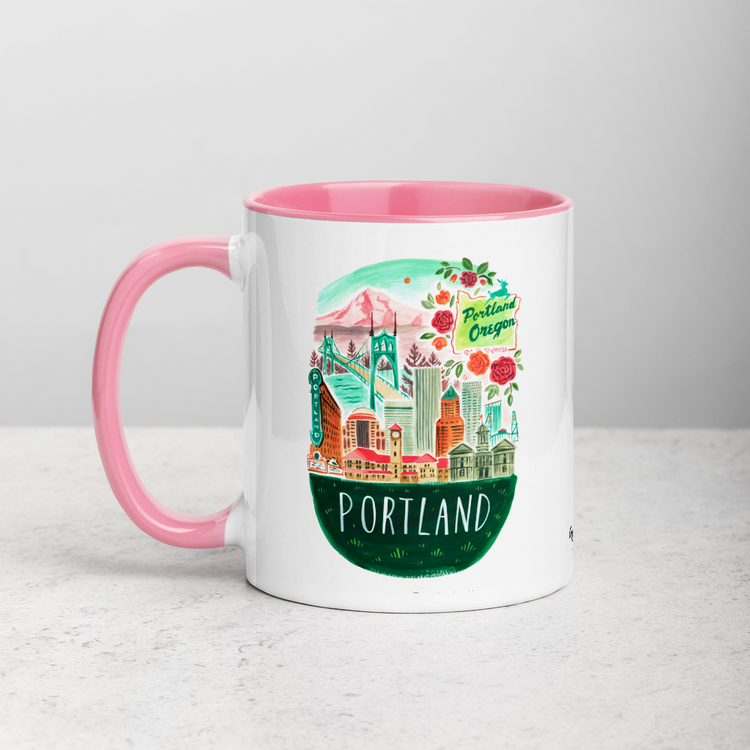 White ceramic coffee mug with pink handle and inside; has Portland Oregon illustration by Angela Staehling