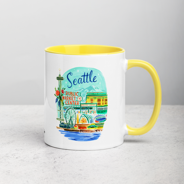 White ceramic coffee mug with yellow handle and inside; has Seattle Washington illustration by Angela Staehling