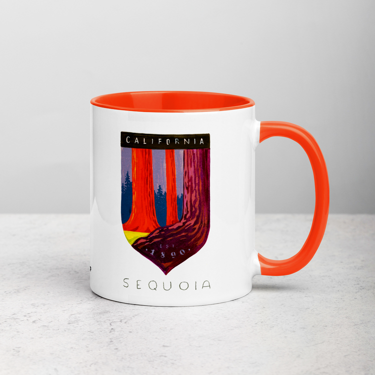 White ceramic coffee mug with orange handle and inside; has Sequoia National Park illustration by Angela Staehling