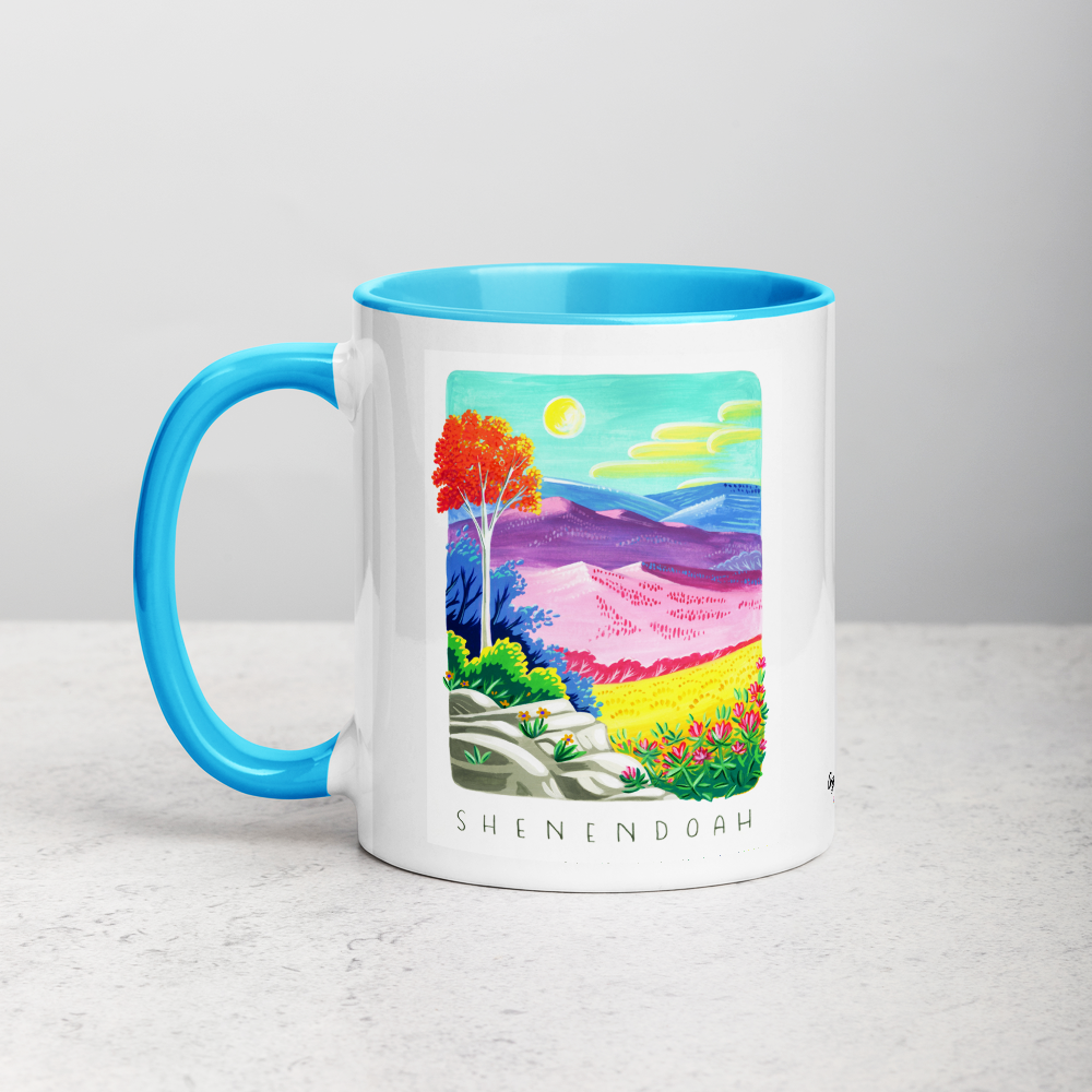 White ceramic coffee mug with blue handle and inside; has Shenandoah National Park illustration by Angela Staehling
