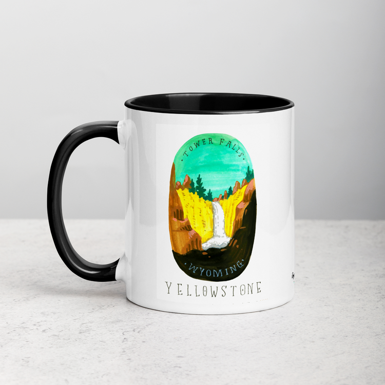 White ceramic coffee mug with black handle and inside; has Yellowstone National Park illustration by Angela Staehling