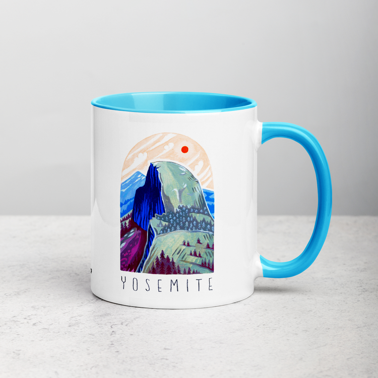 White ceramic coffee mug with blue handle and inside; has Yosemite National Park illustration by Angela Staehling