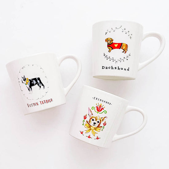 White ceramic mug with dog illustrations by Angela Staehling