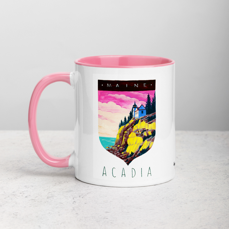 White ceramic coffee mug with pink handle and inside; has Acadia National Park illustration by Angela Staehling