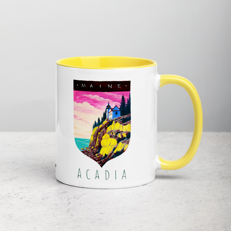 White ceramic coffee mug with yellow handle and inside; has Acadia National Park illustration by Angela Staehling