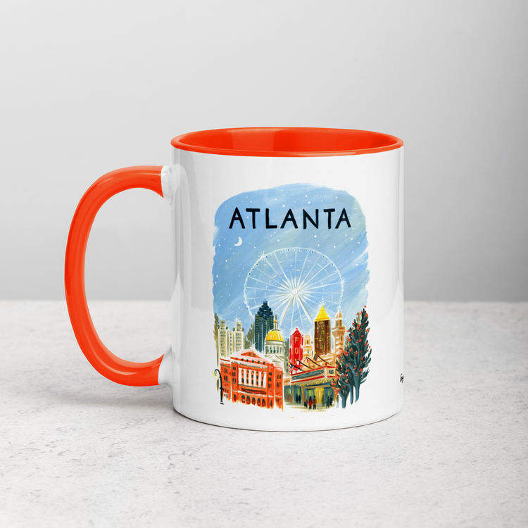 White ceramic coffee mug with orange handle and inside; has Atlanta illustration by Angela Staehling