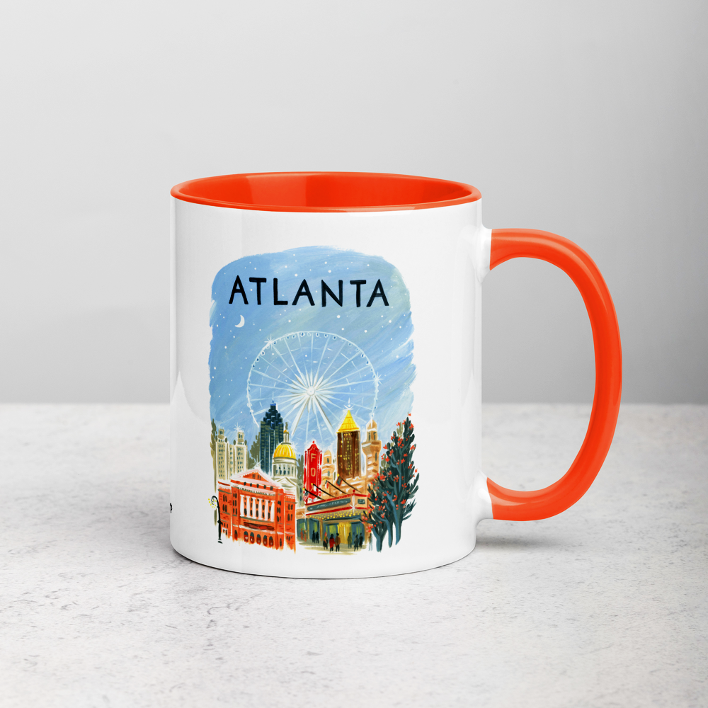 White ceramic coffee mug with orange handle and inside; has Atlanta illustration by Angela Staehling