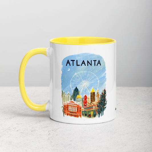 White ceramic coffee mug with yellow handle and inside; has Atlanta illustration by Angela Staehling