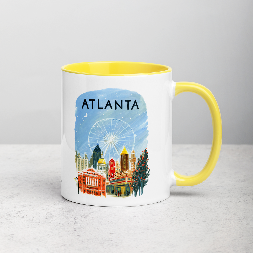 White ceramic coffee mug with yellow handle and inside; has Atlanta illustration by Angela Staehling