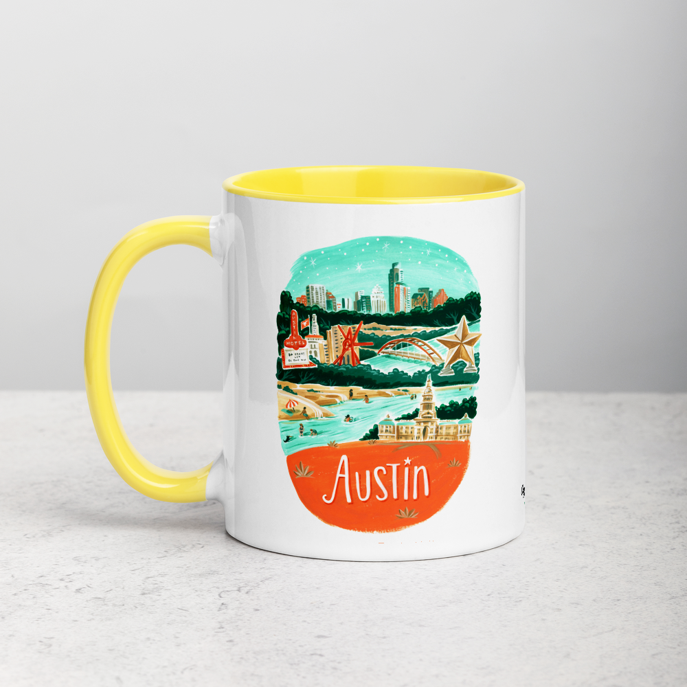 White ceramic coffee mug with yellow handle and inside; has Austin illustration by Angela Staehling