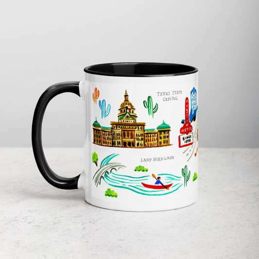 White ceramic coffee mug with black handle and inside; has Austin landmarks illustration by Angela Staehling
