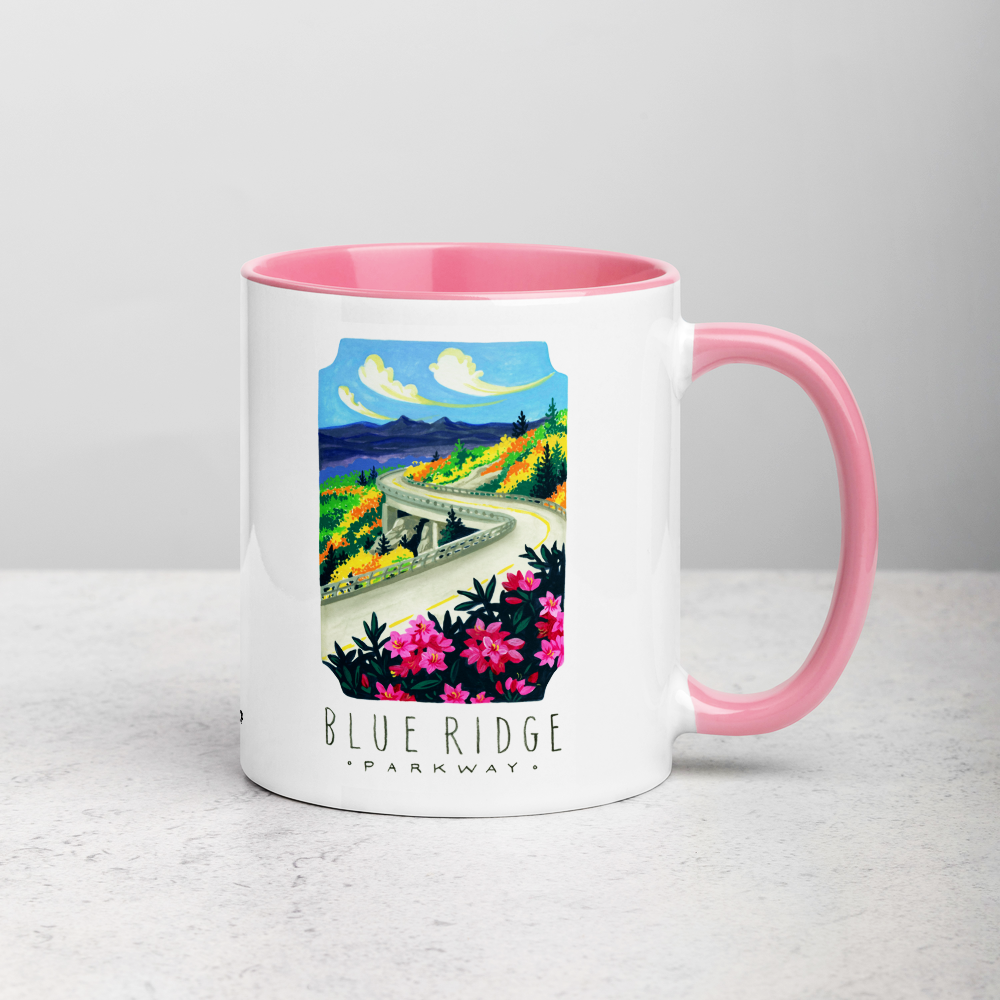 White ceramic coffee mug with pink handle and inside; has Blue Ridge Parkway National Park illustration by Angela Staehling
