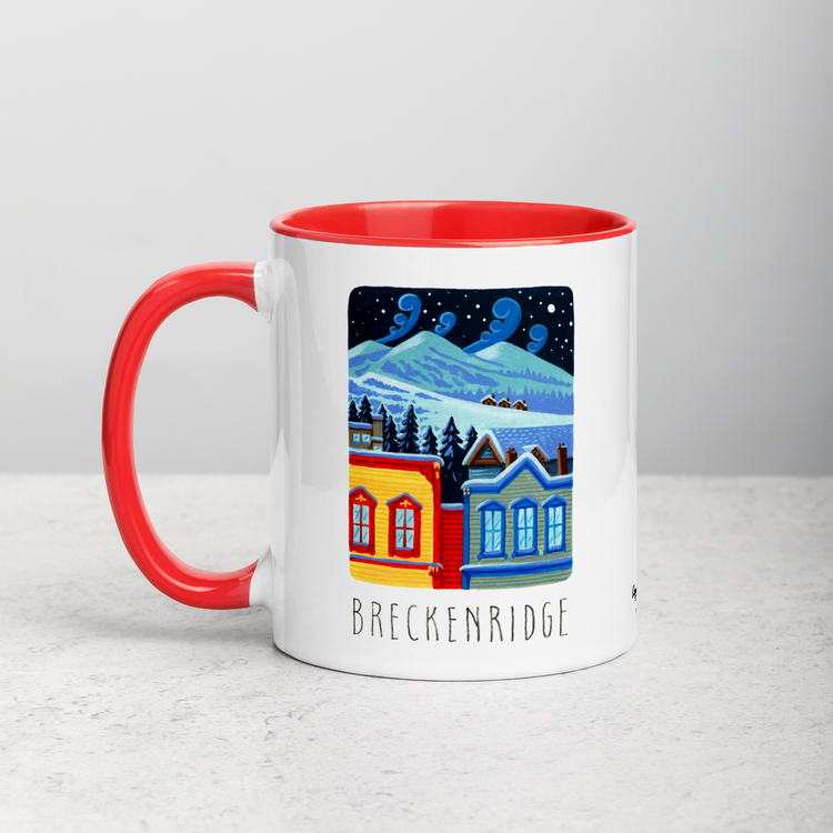 White ceramic coffee mug with red handle and inside; has Breckenridge illustration by Angela Staehling