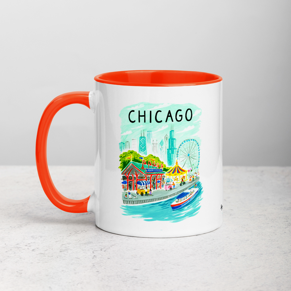 White ceramic coffee mug with orange handle and inside; has Chicago Navy Pier illustration by Angela Staehling