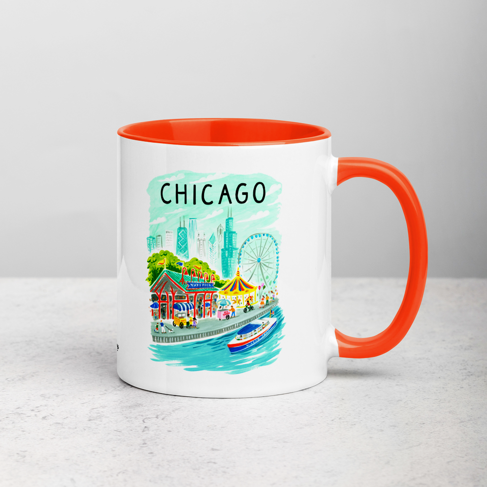 White ceramic coffee mug with orange handle and inside; has Chicago Navy Pier illustration by Angela Staehling