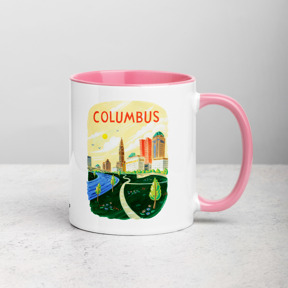 White ceramic coffee mug with pink handle and inside; has Columbus Ohio illustration by Angela Staehling
