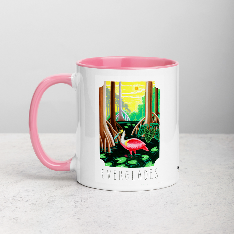White ceramic coffee mug with pink handle and inside; has Everglades National Park illustration by Angela Staehling