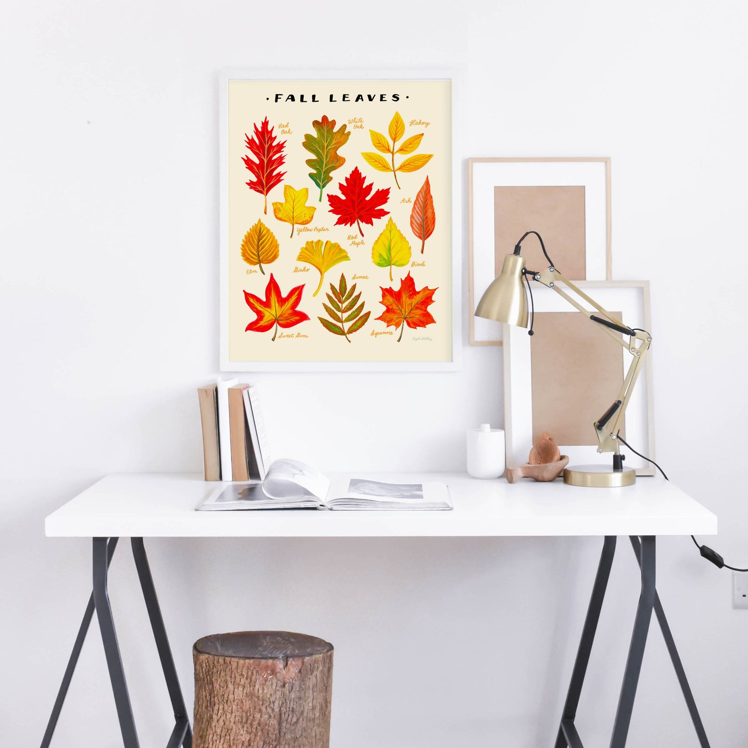 Colorful fall leaves illustration in a white frame above a desk