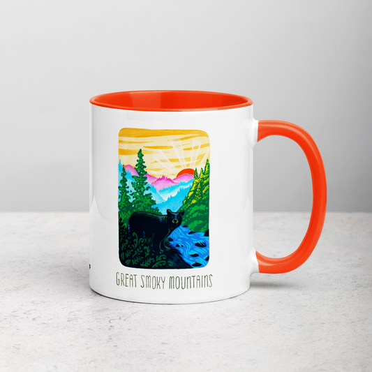 White ceramic coffee mug with orange handle and inside; has Great Smoky Mountains National Park illustration by Angela Staehling