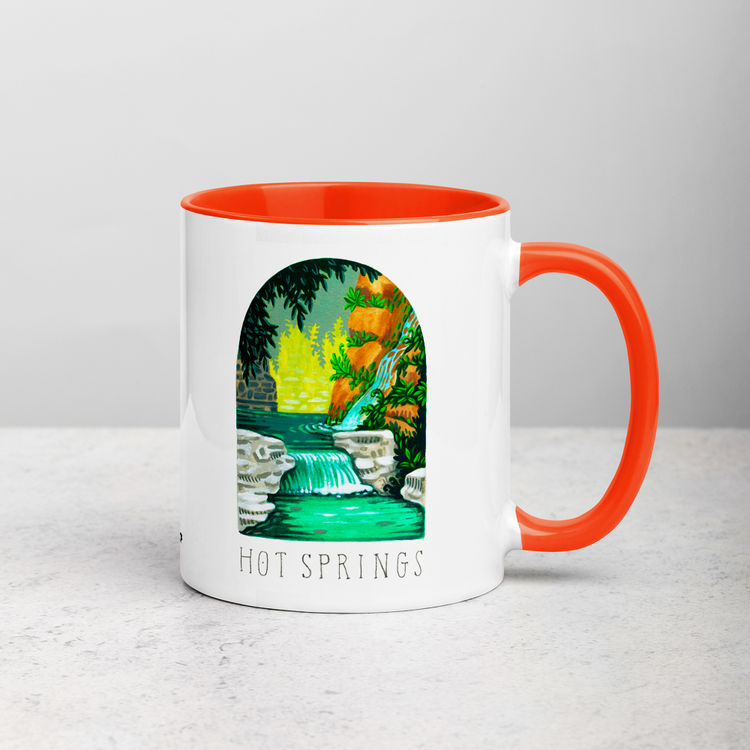 White ceramic coffee mug with orange handle and inside; has Hot Springs National Park illustration by Angela Staehling