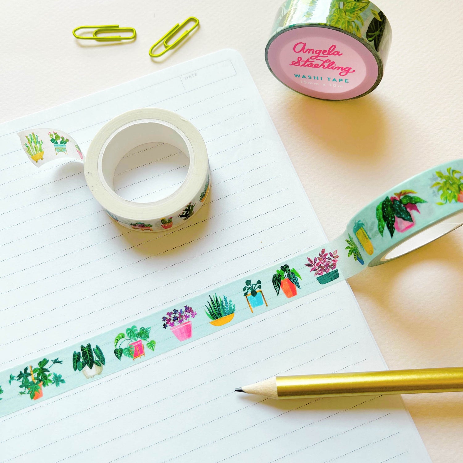 Plant washi tape on notebook with paper clips and pencil