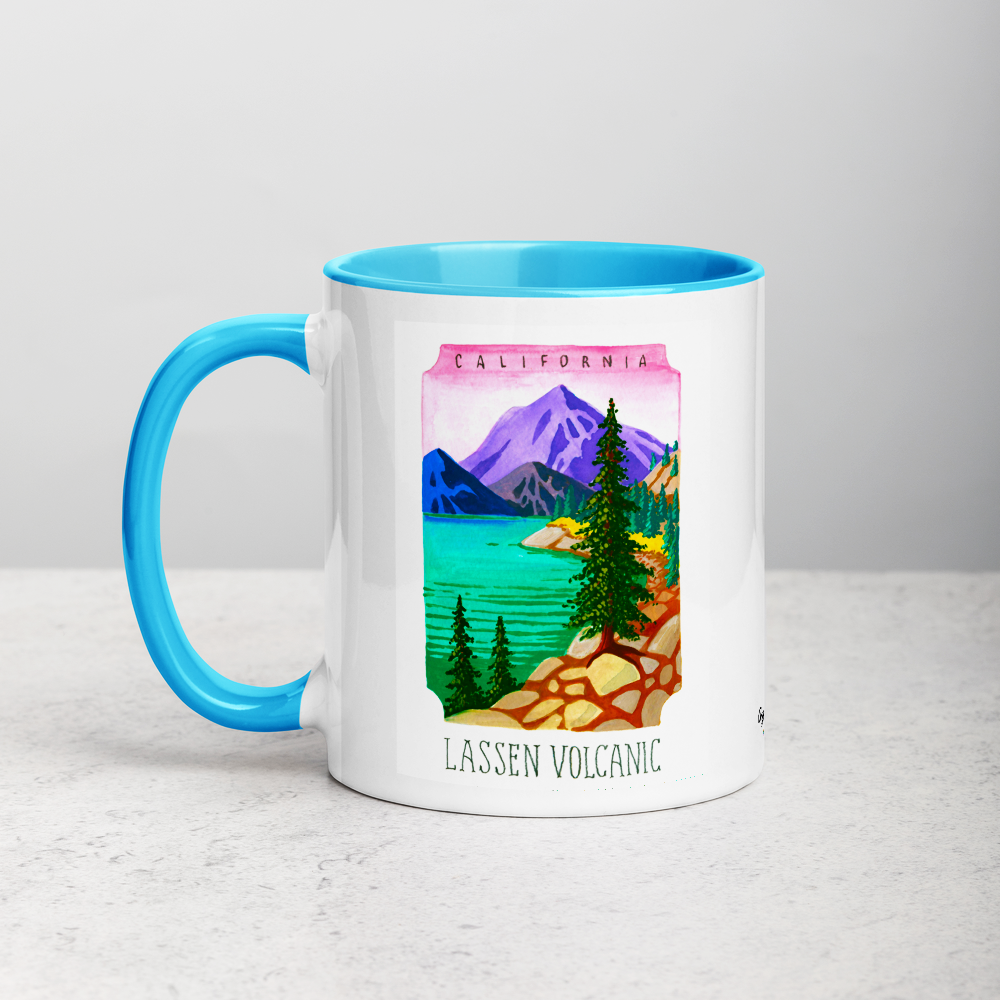 White ceramic coffee mug with blue handle and inside; has Lassen Volcanic National Park illustration by Angela Staehling