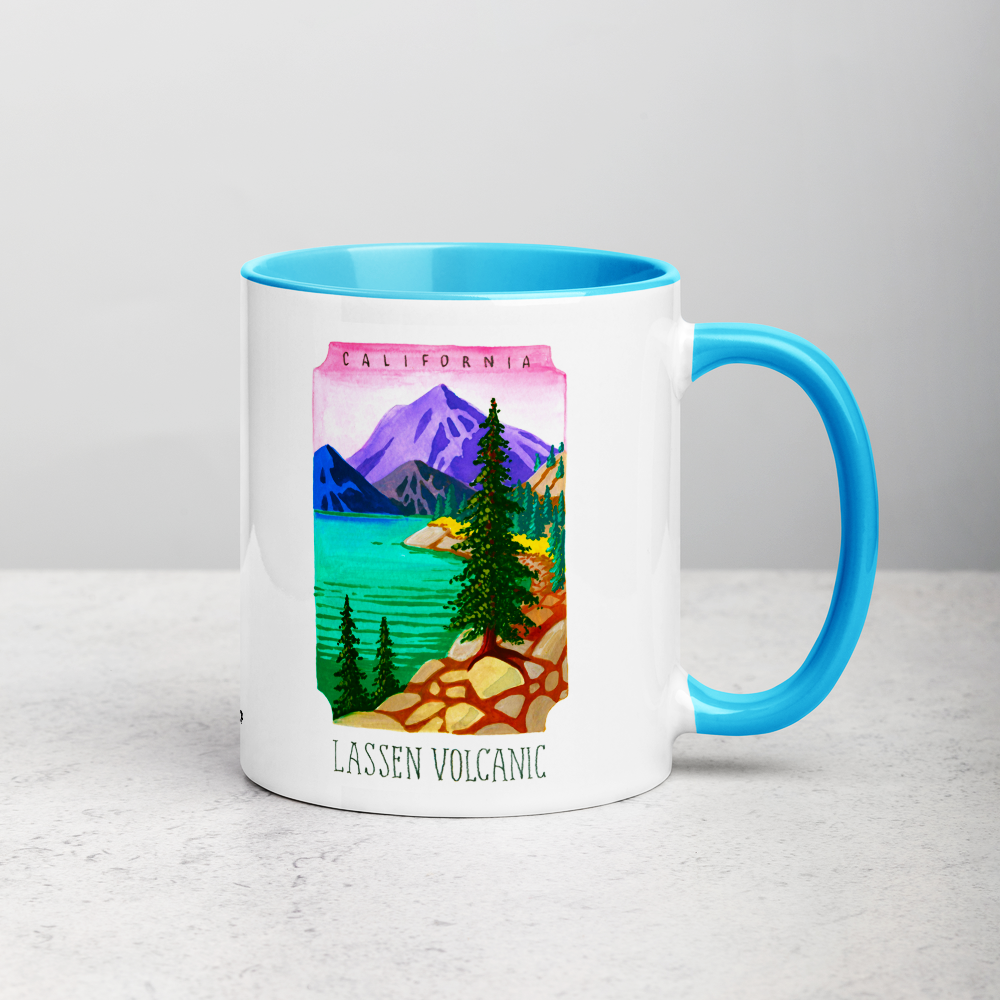 White ceramic coffee mug with blue handle and inside; has Lassen Volcanic National Park illustration by Angela Staehling
